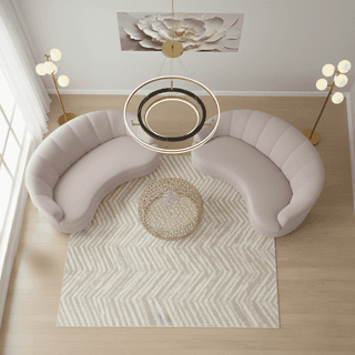 Overhead view of living room with two pink curved sofas and gold accents.