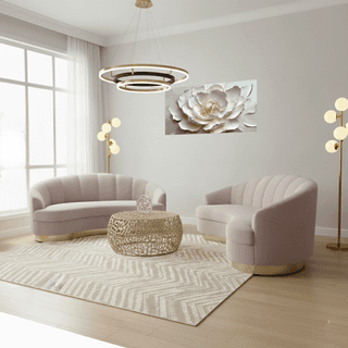 Living room with light pink seating, gold accents, patterned rug, and floral wall art.