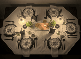Overhead shot of a table set for dinner with black, white, and green accents.