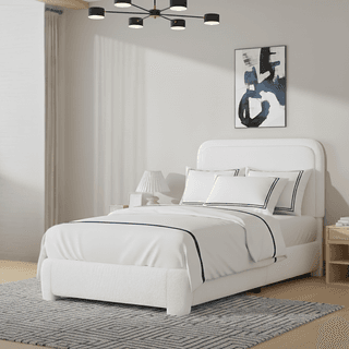 Bedroom with white textured bed, striped rug, abstract art, and modern chandelier.