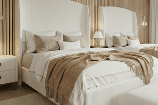 Bedroom with two twin beds. White bedding, light brown throws, and textured white headboards.