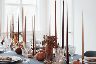 Tu Bshvat. Elegant tablescape with tall candles, pomegranates, berries, and crystal glassware.